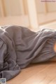 A woman laying on the floor under a blanket.