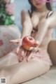 A woman sitting on a couch holding an apple in her hand.