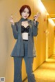 A woman in a gray suit holding a cell phone.