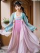 A woman in a pink and blue hanbok is posing for a picture.