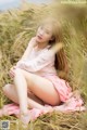 A woman sitting in a field of tall grass.