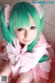 A girl with green hair wearing a pink dress.