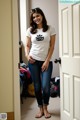 A woman standing in front of a door in a room.