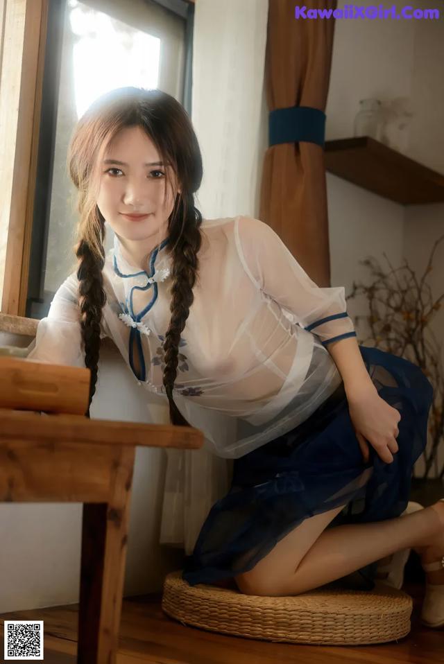 A woman sitting on a chair in front of a window.